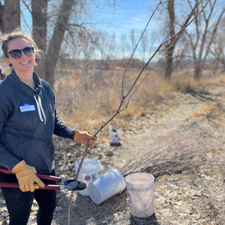 woman holds a willow branch and loppers