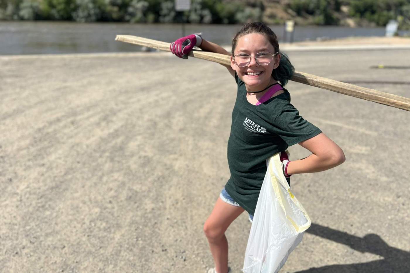 girl hold plank of wood and trash bag