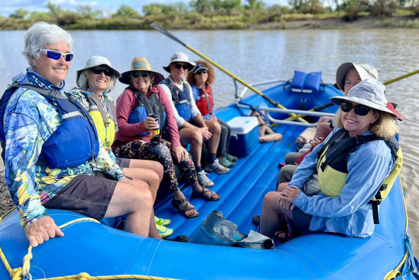 group of people on a blue raft floating down a river