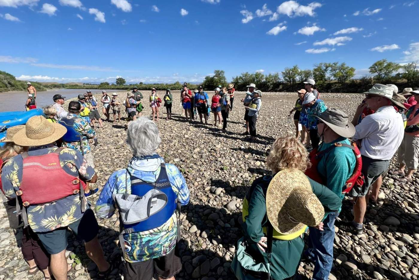 group of people standing in a circle on the riverside