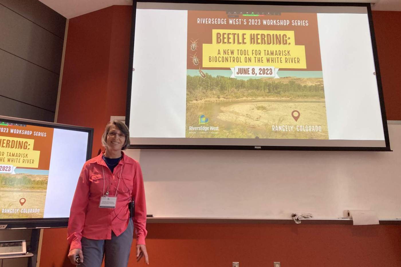 woman stands in front of powerpoint on screen