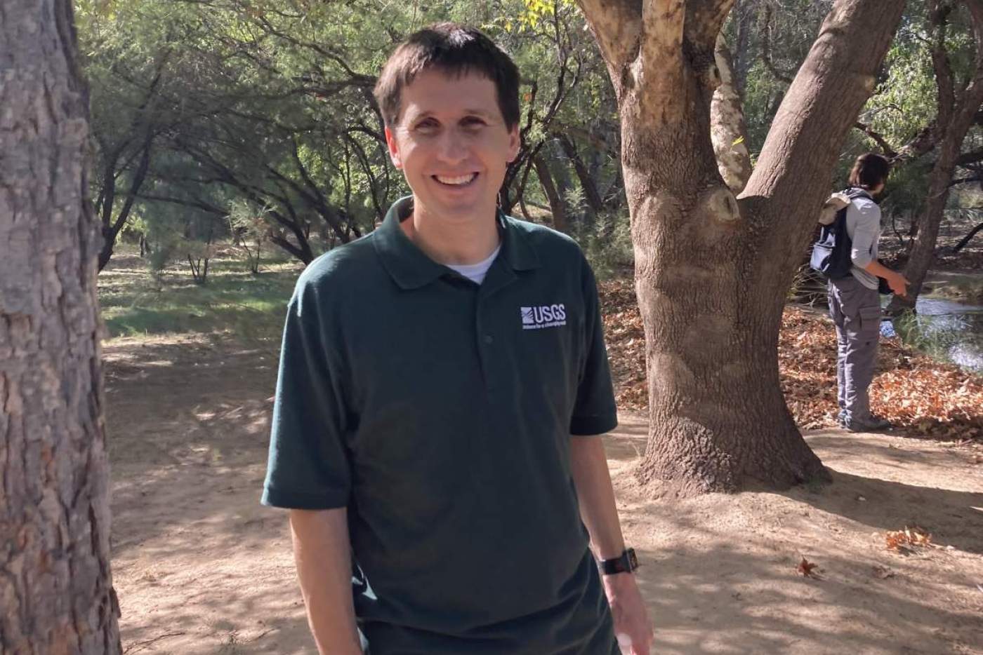 man stands among trees