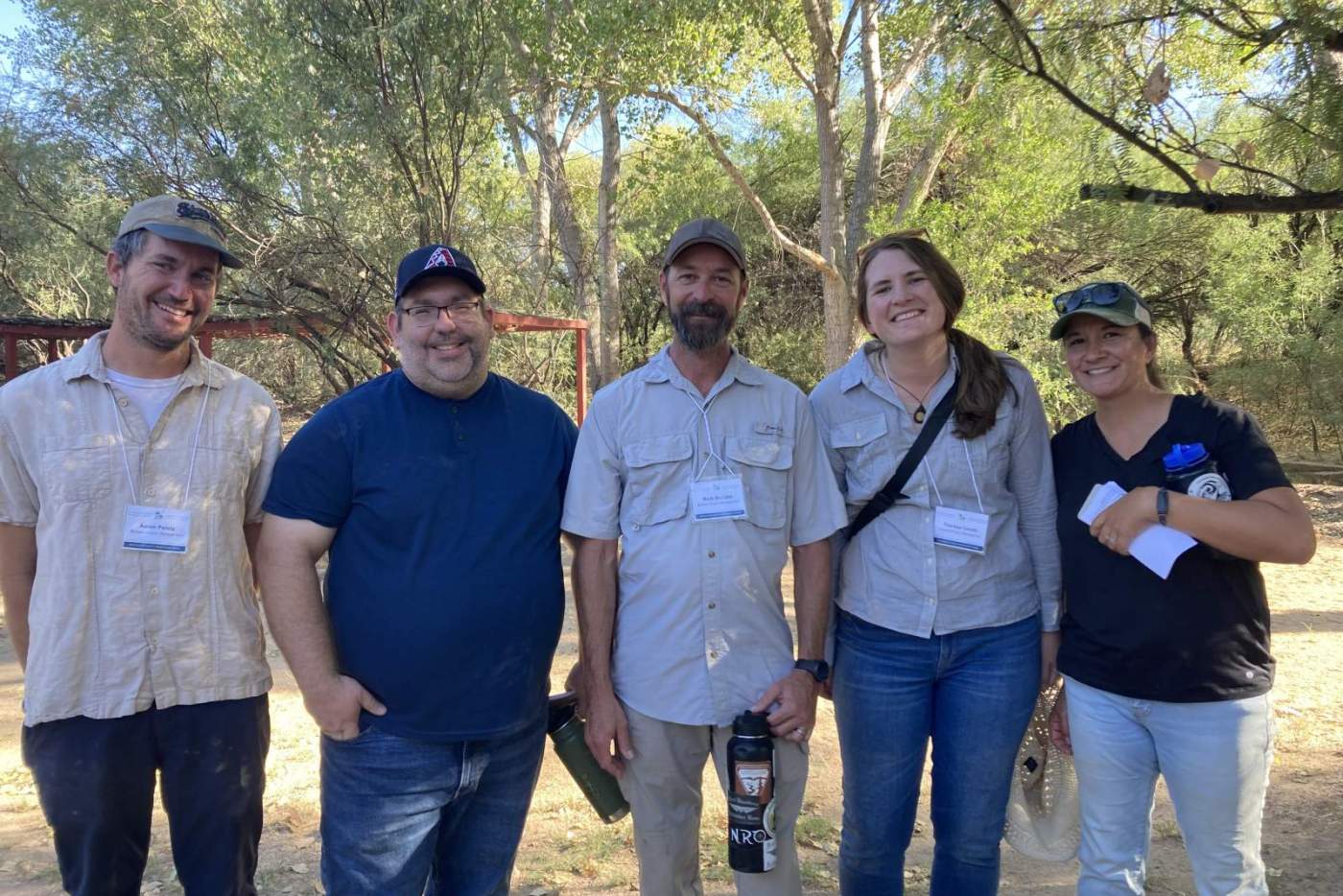 5 people pose for photo with trees in background