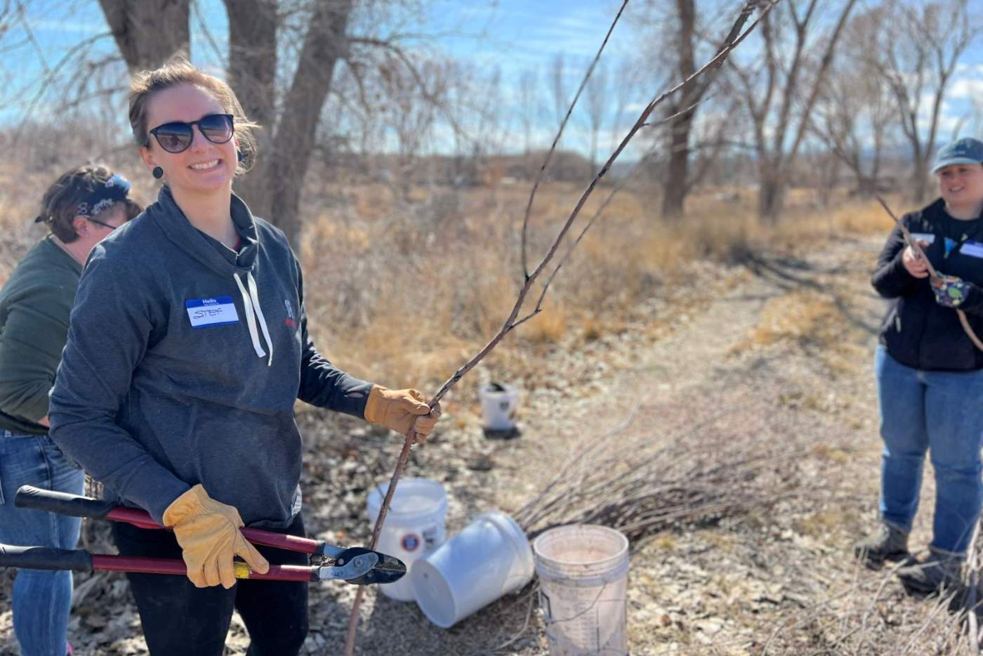 woman holds a willow branch and loppers